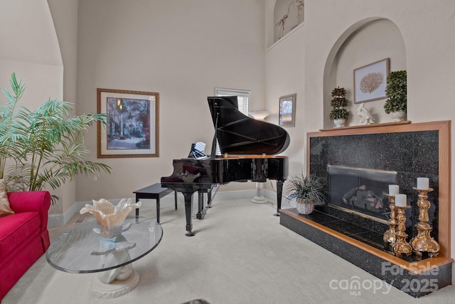 living area with a fireplace, a high ceiling, and carpet flooring