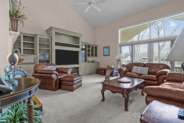 carpeted living room featuring ceiling fan, high vaulted ceiling, and french doors