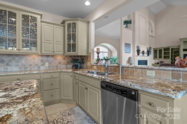 kitchen with sink, cream cabinets, light stone countertops, and dishwasher