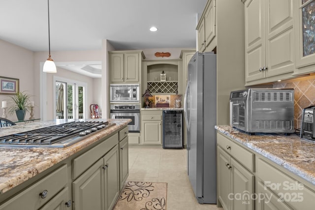 kitchen with backsplash, stainless steel appliances, wine cooler, light stone countertops, and decorative light fixtures