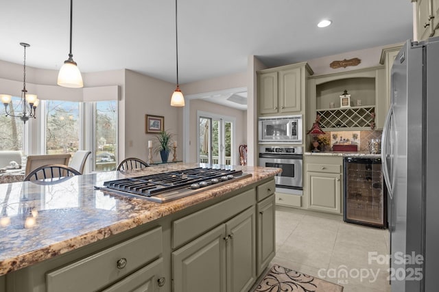 kitchen with appliances with stainless steel finishes, a notable chandelier, decorative backsplash, decorative light fixtures, and beverage cooler