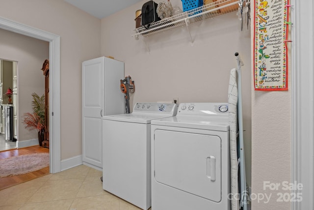 washroom featuring light tile patterned floors and washing machine and dryer