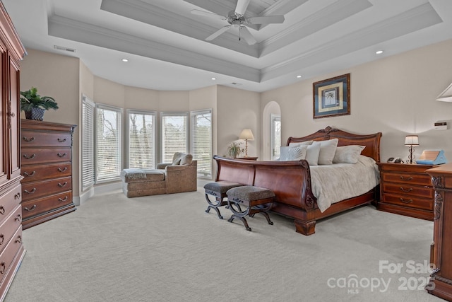 bedroom with crown molding, ceiling fan, a tray ceiling, and light carpet