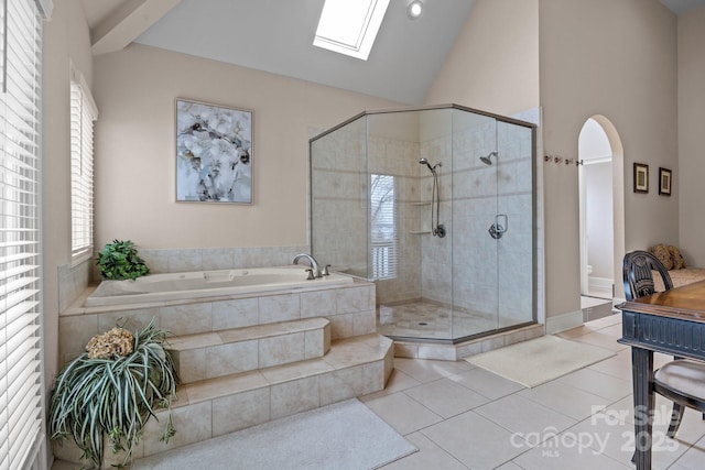 bathroom with separate shower and tub, vaulted ceiling with skylight, and tile patterned floors