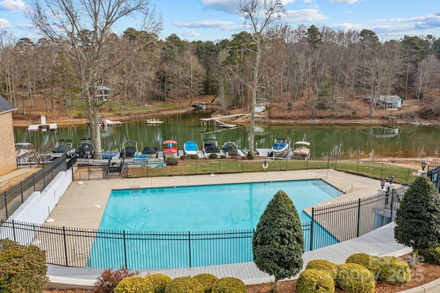 view of swimming pool with grilling area and a water view