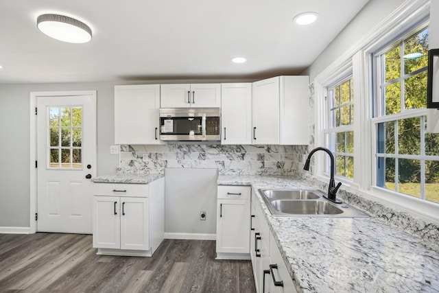 kitchen with plenty of natural light, sink, decorative backsplash, and white cabinets