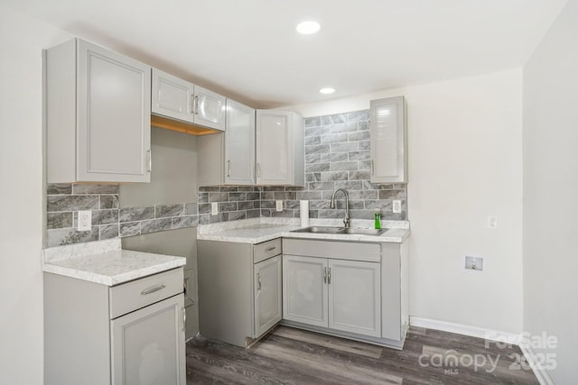 kitchen featuring tasteful backsplash, gray cabinets, and sink