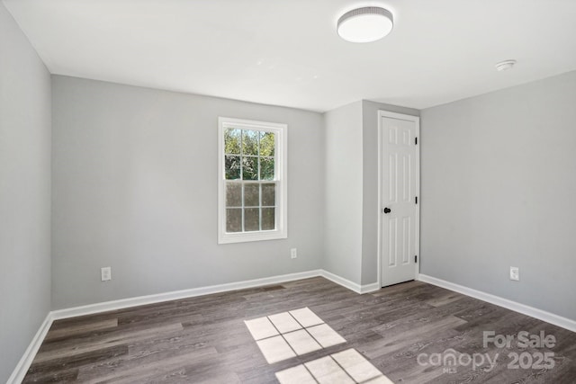 unfurnished room featuring dark wood-type flooring