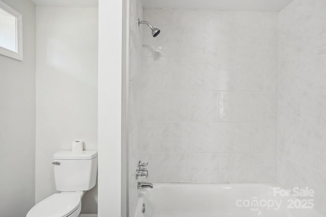 bathroom with tiled shower / bath and toilet