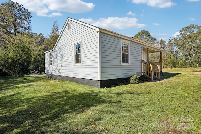 view of side of home with a yard