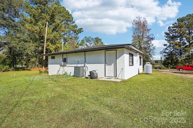 back of property with cooling unit and a lawn