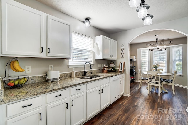 kitchen featuring pendant lighting, white cabinetry, sink, white dishwasher, and dark wood-type flooring