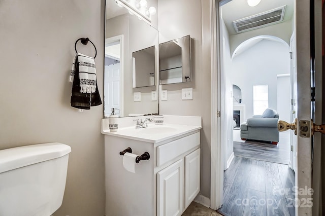 bathroom with hardwood / wood-style flooring, vanity, and toilet