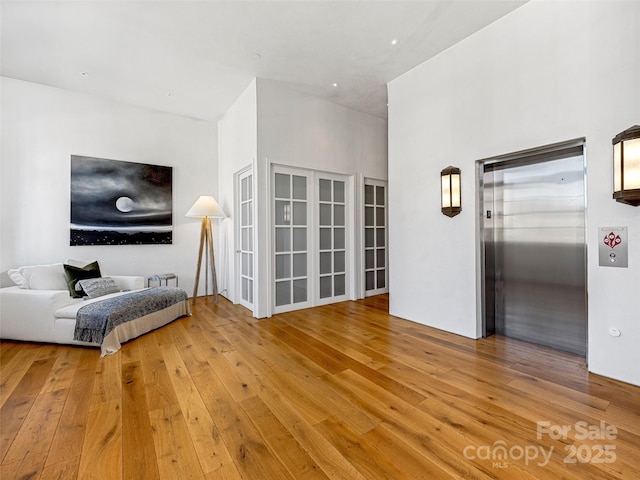 living room with elevator and light hardwood / wood-style flooring