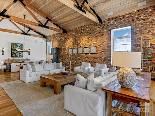 living room with hardwood / wood-style flooring, beam ceiling, high vaulted ceiling, brick wall, and wooden ceiling