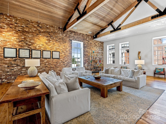 living room with wood ceiling, high vaulted ceiling, wood-type flooring, brick wall, and beamed ceiling