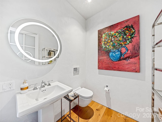 bathroom with sink, hardwood / wood-style floors, and toilet