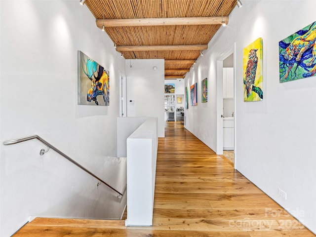 hallway featuring beam ceiling, wood-type flooring, and wooden ceiling