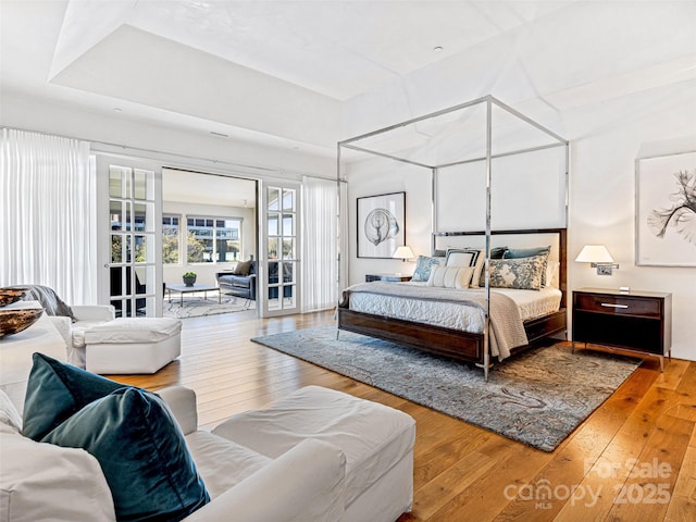 bedroom featuring access to exterior and hardwood / wood-style floors