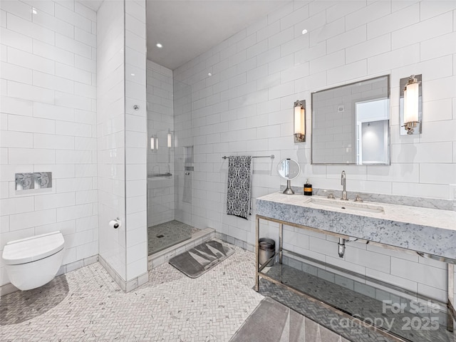 bathroom with sink, tile walls, a tile shower, tile patterned floors, and toilet