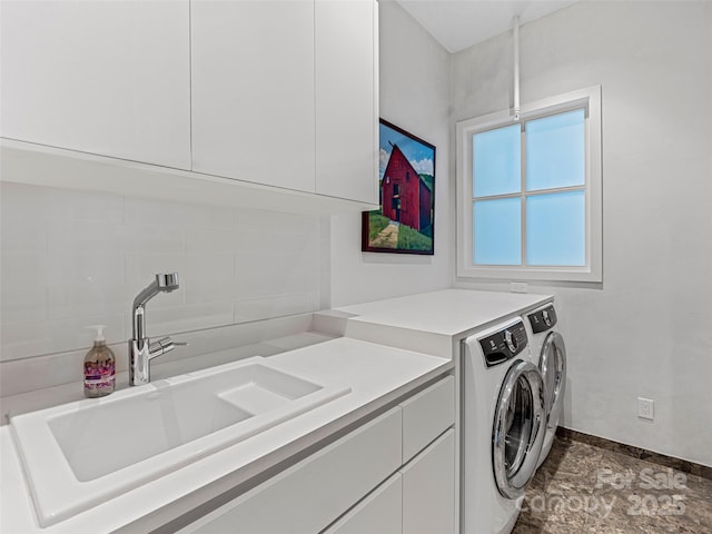 clothes washing area featuring cabinets, sink, and independent washer and dryer