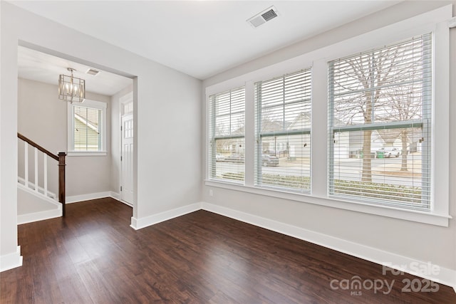 foyer featuring dark wood-type flooring and a chandelier