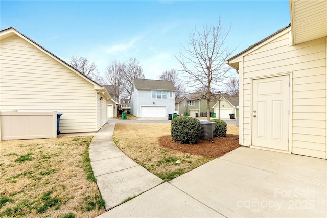 view of yard featuring central AC and a garage