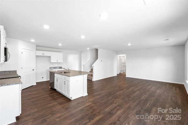 kitchen featuring white cabinetry, stainless steel appliances, light stone countertops, a center island with sink, and dark hardwood / wood-style flooring