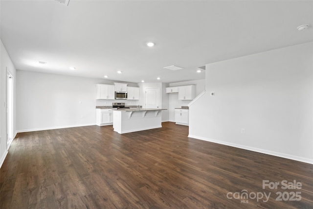 unfurnished living room with dark wood-type flooring