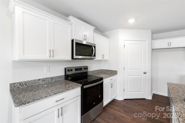 kitchen featuring white cabinetry, stainless steel appliances, light stone countertops, and dark wood-type flooring