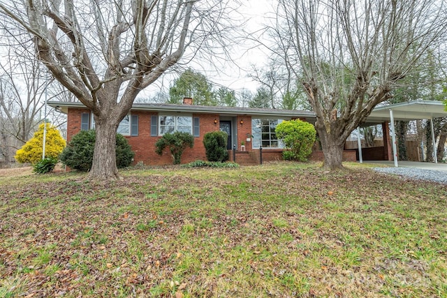 single story home featuring a chimney, a front lawn, and brick siding