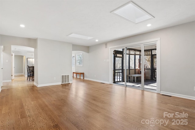 spare room with plenty of natural light, hardwood / wood-style floors, and a skylight