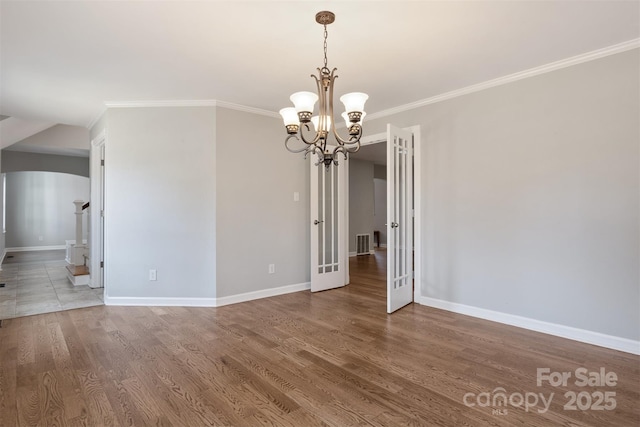 unfurnished room with ornamental molding, a chandelier, and hardwood / wood-style floors