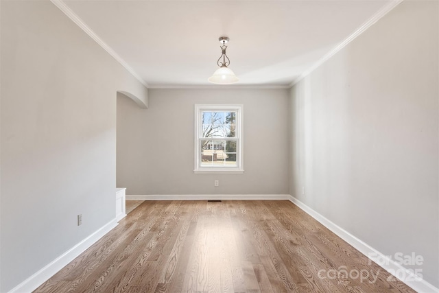 unfurnished room featuring ornamental molding and light hardwood / wood-style floors