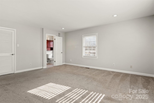 unfurnished bedroom featuring ensuite bath and light carpet