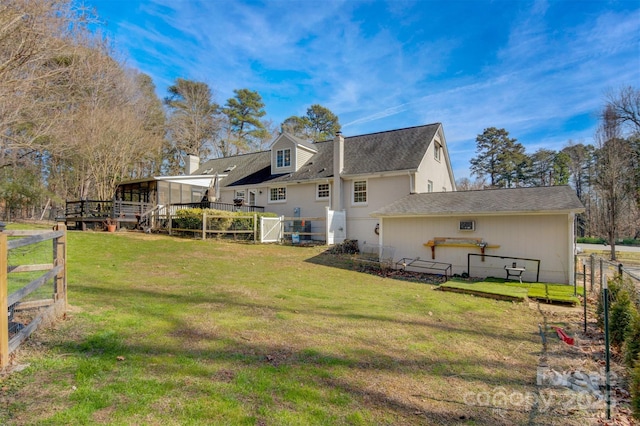 back of house featuring a wooden deck and a yard