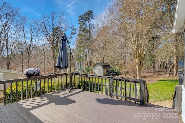 wooden terrace featuring a yard and a storage shed