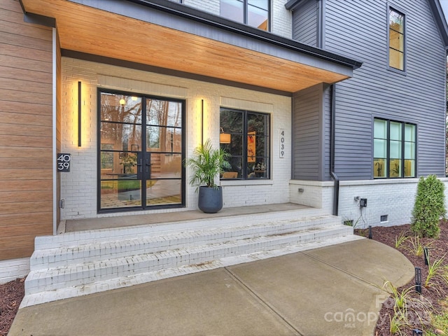 view of exterior entry featuring covered porch