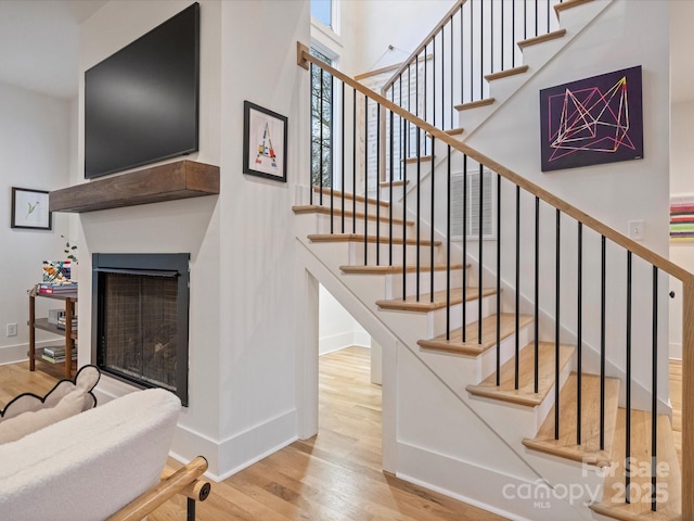 stairway featuring a high ceiling and wood-type flooring