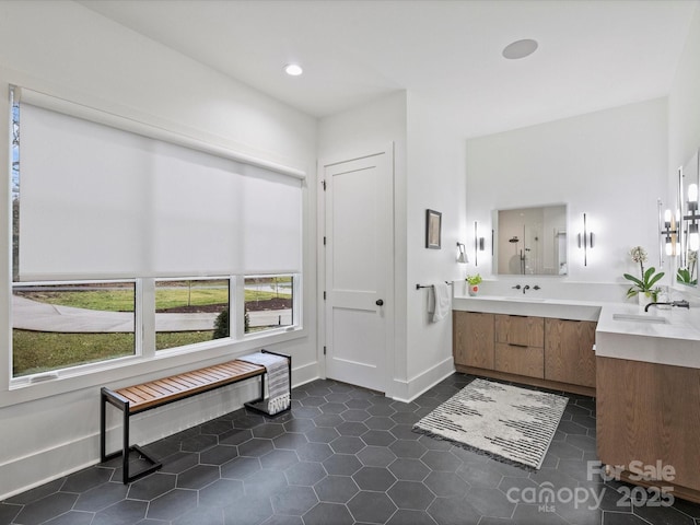 bathroom featuring tile patterned flooring, vanity, and walk in shower