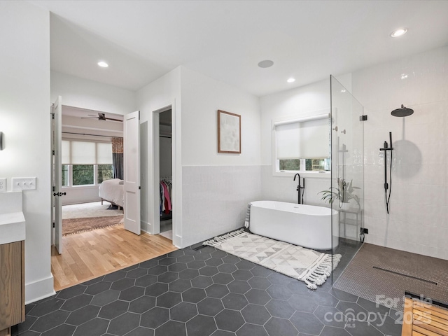 bathroom with separate shower and tub, tile walls, and tile patterned floors