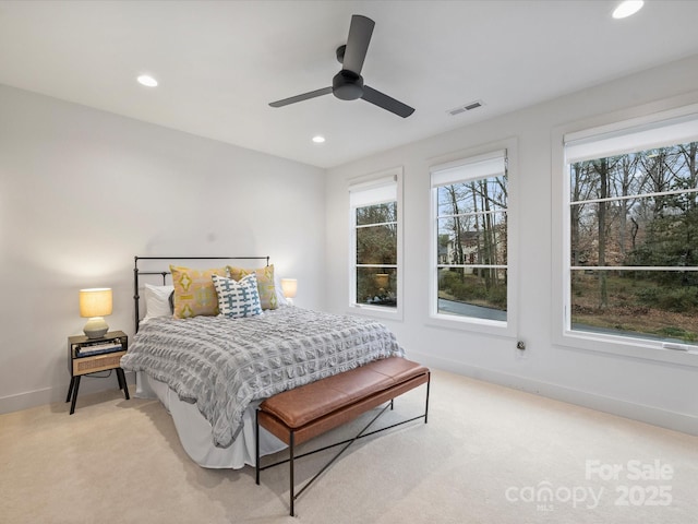 carpeted bedroom with multiple windows and ceiling fan