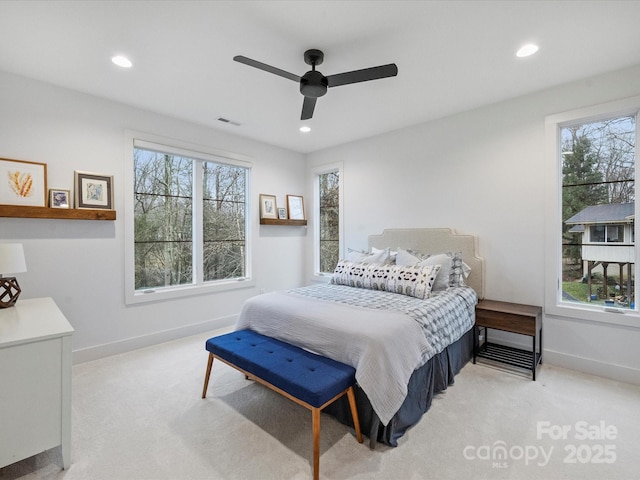 carpeted bedroom with ceiling fan and multiple windows