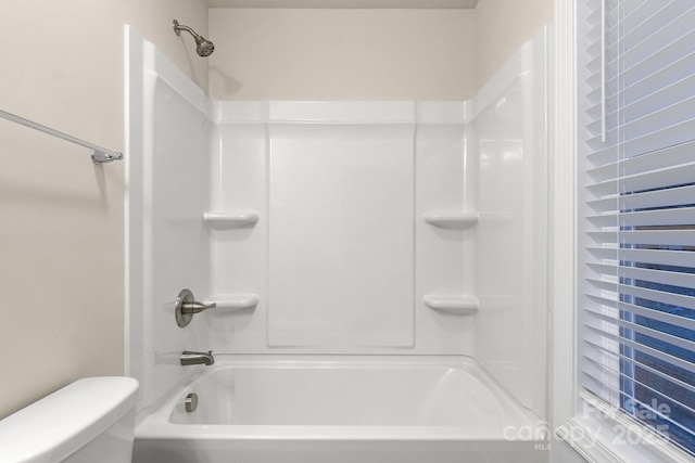 bathroom featuring shower / bathtub combination and toilet