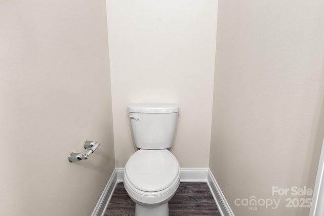 bathroom featuring toilet, baseboards, and wood finished floors