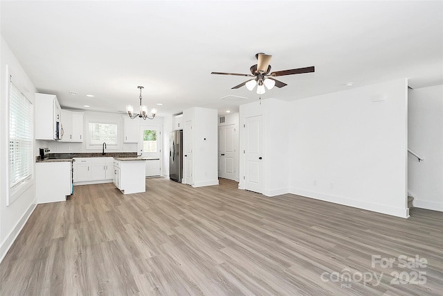 unfurnished living room with recessed lighting, baseboards, light wood finished floors, visible vents, and ceiling fan with notable chandelier