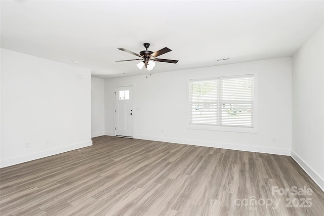 unfurnished living room featuring ceiling fan, baseboards, visible vents, and wood finished floors