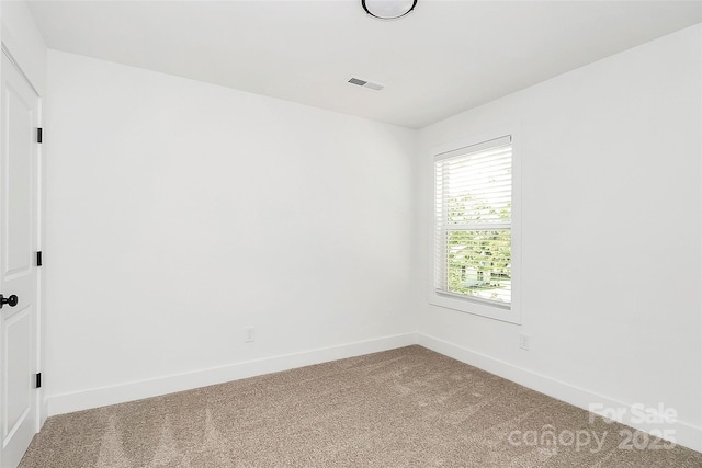 empty room with carpet flooring, baseboards, and visible vents