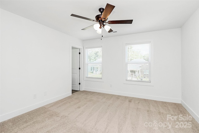 carpeted empty room featuring baseboards and a ceiling fan