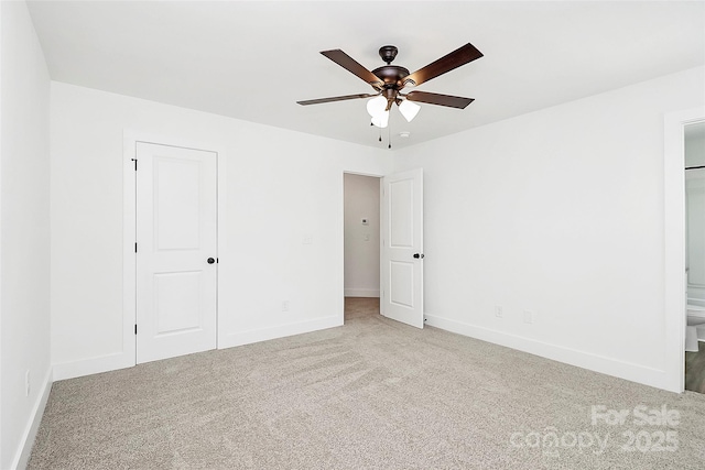 unfurnished bedroom with baseboards, ensuite bathroom, ceiling fan, and carpet floors